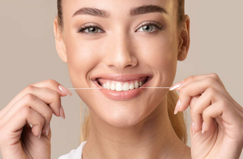 A woman flossing her front teeth.