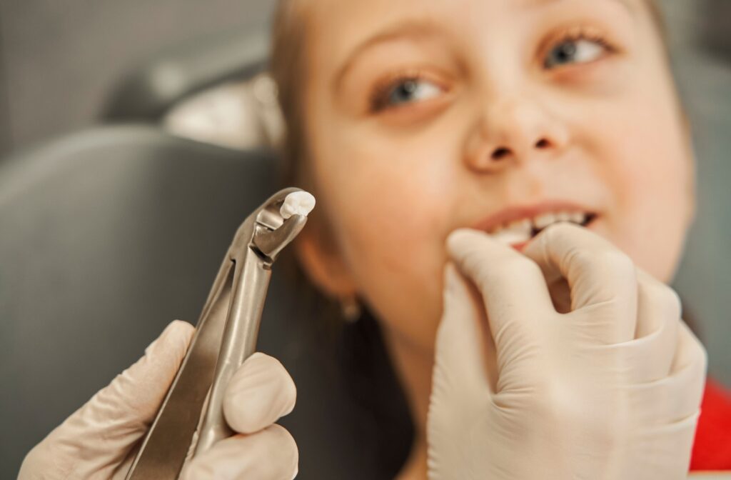 A dentist carefully places gauze into a young patient’s mouth after extracting a bothersome tooth.