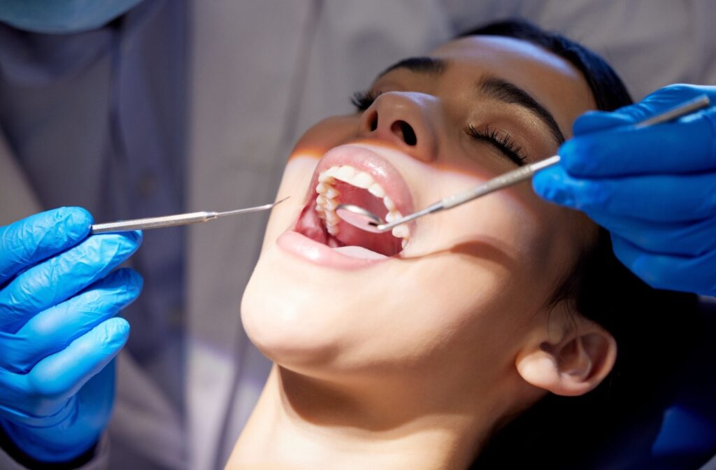 Patient receiving a dental exam to check for signs of tooth decay.